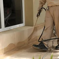 General pest control technician spraying exterior perimeter around a home in Springfield, MO